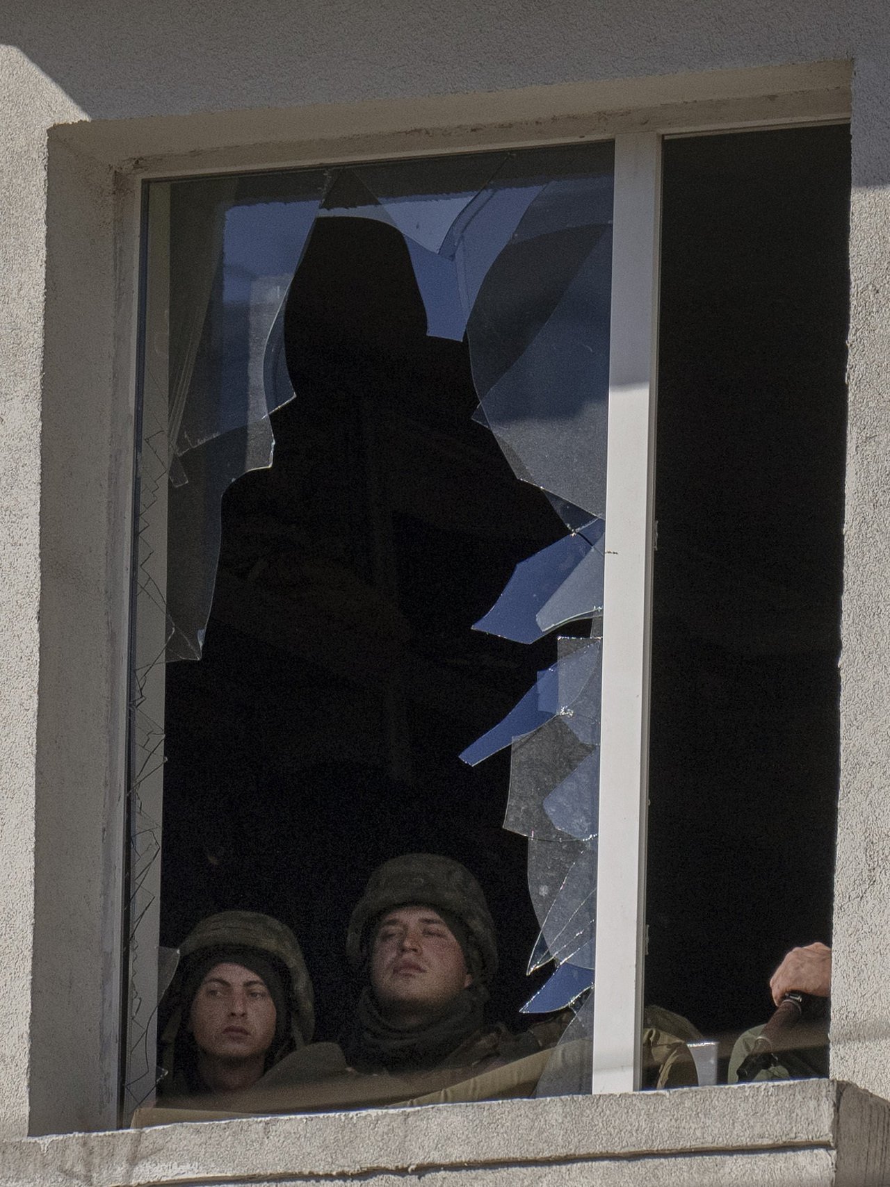 Február 26. Ukrán katonák kinéznek egy katonai létesítmény kitört ablakán Kijevben.jpg