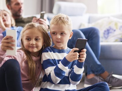 children-using-mobile-phone-living-room